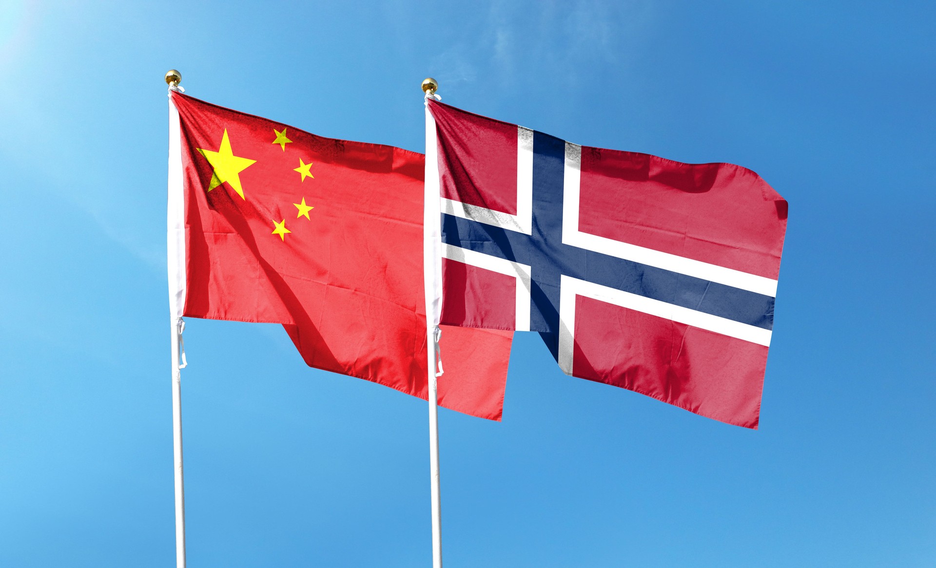 Chinese flag and Norwegian flag. waving in the blue sky